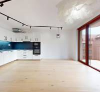 | Prémiové bývanie v ZWIRNe I Pekný 2i byt I  - Dvojizbový byt s veľkými oknami, bielou kuchyňou a podlahou s dreveným dekorom.