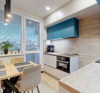 PREDAJ, 3 izbový dizajnový byt na Lidickom námestí, Košice - Furča - Kuchyňa v 3-izbovom byte s dreveným dekorom, kvetmi a jedálenským stolom.