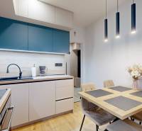 PREDAJ, 3 izbový dizajnový byt na Lidickom námestí, Košice - Furča - Kuchyňa v 3-izbovom byte s dreveným dekorom, moderným osvetlením a jedálenským stolom.