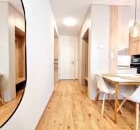 REZERVOVANÉ I Posledný investičný krásny 2-izbový byt | 62 m² | - Interiér 2-izbového bytu s podlahou s dreveným dekorom a štýlovým nábytkom.