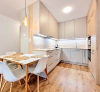 REZERVOVANÉ I Posledný investičný krásny 2-izbový byt | 62 m² | - Kuchyňa v 2-izbovom byte s podlahou s dreveným dekorom a jedálenským stolom.