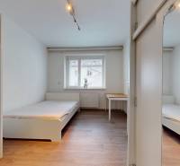 Príjemný a priestranný 3-izbový byt | 83 m² |  - Izba v 3-izbovom byte s posteľou, skriňou a podlahou s dreveným dekorom.