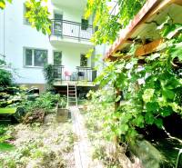 Príjemný a priestranný 3-izbový byt | 83 m² |  - Záhrada pred bytovým domom obklopená bujnou vegetáciou s balkónom.