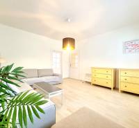 Príjemný a priestranný 3-izbový byt | 83 m² |  - Svetlá obývacia izba so sivou pohovkou a dvomi žltými komodami, 3-izbový byt.