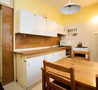NA PREDAJ,3-IZBOVÝ TEHLOVÝ BYT,KOŠICE-ŠACA - Kuchyňa s dreveným stolom v 3-izbovom byte. Skrinky, sporák, chladnička s magnetkami.