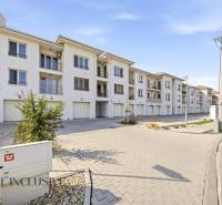 Na prenájom 2-izb. byt s terasou, Dun. Streda -Florida - Súbor bielych budov a parkovacích miest v Dunajskej Strede, ideálny pre 4-izbový byt.