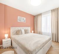 Na prenájom 2-izb. byt s terasou, Dun. Streda -Florida - Spálňa s oranžovou stenou a podlahou s dreveným dekorom v 4-izbovom byte.