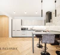 Na prenájom 2-izb. byt s terasou, Dun. Streda -Florida - Kuchyňa v 4-izbovom byte s podlahou s dreveným dekorom a štýlovými svietidlami.