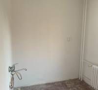 2 IZBOVÝ BYT, KOŠICE – ŠIRŠIE CENTRUM - Prázdna miestnosť v 2-izbovom byte bez podlahovej krytiny a s umývadlom.