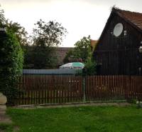 PREDAJ – Rodinný dom s druhou samostatnou stavbou, garážou  - Drevený rodinný dom v Blatnici s dreveným plotom a satelitnou anténou.