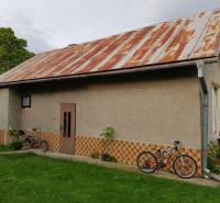 PREDAJ – Rodinný dom s druhou samostatnou stavbou, garážou  - Rodinný dom v Blatnici na Blatnici s plechovou strechou a bicyklami v záhrade.