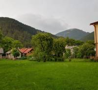 PREDAJ – Rodinný dom s druhou samostatnou stavbou, garážou  - Rodinný dom v Blatnici obklopený zelenými stromami a pohorím.