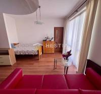 Štýlový 1 izbový byt v Piešťanoch s balkónom, vo výbornej lokalite - Na fotografii je 1-izbový byt, zahŕňajúci posteľ, červenú pohovku a sklenený stôl.