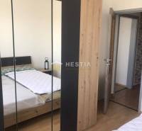 NOVINKA Prenájom 2 izbového bytu na Robotníckej ulici, voľný od 01.05. - Spálňa s posteľou, skriňou a podlahou s dreveným dekorom v 2-izbovom byte.