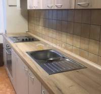 NOVINKA Prenájom 2 izbového bytu na Robotníckej ulici, voľný od 01.05. - Kuchyňa v 2-izbovom byte s podlahou s dreveným dekorom a svetlým nábytkom.