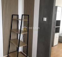 NOVINKA Prenájom 2 izbového bytu na Robotníckej ulici, voľný od 01.05. - Interiér 2-izbového bytu s policou a stenami s dreveným dekorom.