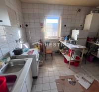 Na predaj rodinný dom, gastro prevádzka – Senica, Robotnícka ulica - Kuchyňa s podlahou z dlaždíc, sporákom a riadmi na poličke, gastro priestory.