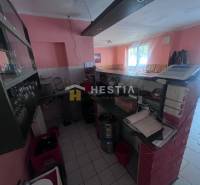 Na predaj rodinný dom, gastro prevádzka – Senica, Robotnícka ulica - Interiér gastro priestorov s barovým pultom, pokladňou a pohármi na poličke.