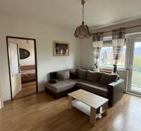 Na predaj 3i byt Pukanec - Obývacia izba v 3-izbovom byte so sedačkou a podlahou s dreveným dekorom.