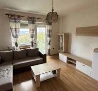 Na predaj 3i byt Pukanec - Obývačka v 3-izbovom byte s pohodlnou sedačkou, podlahou s dreveným dekorom a balkónom.