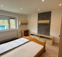 Na predaj 3i byt Pukanec - Spálňa s kamenným obkladom a podlahou s dreveným dekorom v 3-izbovom byte.