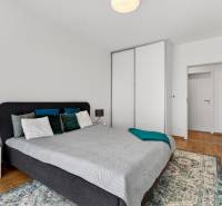 Predaj 2-izbový byt GREEN VILLAGE, 51m2, loggia, Dunajská Lužná - Spálňa v 2-izbovom byte s posteľou, nočným stolíkom a skriňou.