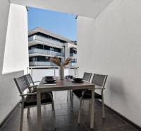 Predaj 2-izbový byt GREEN VILLAGE, 51m2, loggia, Dunajská Lužná - Balkón 2-izbového bytu na Orechovej v Dunajskej Lužnej s vonkajším stolom a stoličkami.