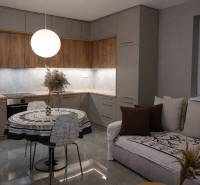 Predaj 2-izbový byt GREEN VILLAGE,44m2, loggia, Dunajská Lužná - Kuchyňa v 2-izbovom byte s podlahou s dreveným dekorom a okrúhlym stolom.