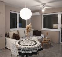 Predaj 2-izbový byt GREEN VILLAGE,44m2, loggia, Dunajská Lužná - Obývacia izba s pohovkou, okrúhlym stolom a ozdobným svietidlom v 2-izbovom byte.