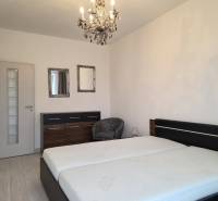 PRENÁJOM - 3 izbový byt v novostavbe - Nitra, blízko centra - Spálňa so svetlou podlahou s dreveným dekorom, pohodlnou posteľou a lustrom v 3-izbovom byte.