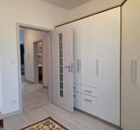 PRENÁJOM - 3 izbový byt v novostavbe - Nitra, blízko centra - Interiér 3-izbového bytu s bielou vstavanou skriňou a podlahou s dreveným dekorom.