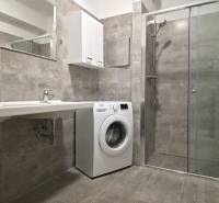 PRENÁJOM - 3 izbový byt v novostavbe - Nitra, blízko centra - Kúpeľňa v 3-izbovom byte s práčkou, sprchovým kútom a umývadlom na šedých obkladoch.