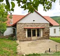 Unikátny meštiansky dom s veľkou záhradou – história, štýl a potenciál - Rodinný dom v Dobroči s kamennou fasádou, tradičnou strechou a príjemnou záhradou.