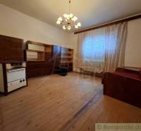 Pôvodný päťizbový rodinný dom s hospodárskymi budovami blízko centra o - Obývacia izba v rodinnom dome s dreveným dekorom, záclonami a pohovkou.