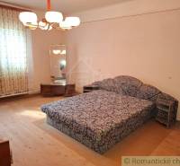 Pôvodný päťizbový rodinný dom s hospodárskymi budovami blízko centra o - Izba v rodinnom dome s kobercovým nábytkom a zrkadlom, podlaha s dreveným dekorom.