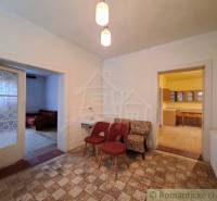 Pôvodný päťizbový rodinný dom s hospodárskymi budovami blízko centra o - Interiér rodinného domu s kreslami, umývadlom, kuchyňou a dvomi otvorenými dverami.