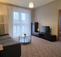 PRENÁJOM - Priestranný 3 izbový byt - Nitra, Centrum - Obývačka v 3-izbovom byte s pohovkou, televízorom, stolíkom a balkónovými dverami.