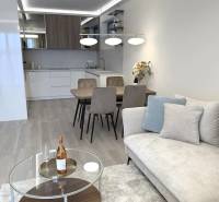2 izbový A.3.1.- 58,91 m2 Bell Residence  - Obývacia izba v 2-izbovom byte s podlahou s dreveným dekorom, pohovkou a jedálenským stolom.