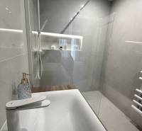2 izbový A.3.1.- 58,91 m2 Bell Residence  - Kúpeľňa so sprchovým kútom a umývadlom v 2-izbovom byte s podlahou s dreveným dekorom.