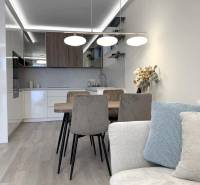 2 izbový A.3.1.- 58,91 m2 Bell Residence  - Svetlá kuchyňa s jedálenským stolom v 2-izbovom byte s podlahou s dreveným dekorom.