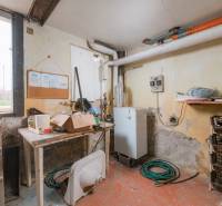 Na predaj rodinný dom Trnava, Zelenečská ulica, pozemok 1085 m2 - Suterén Rodinného domu s kotlom, regálmi, hadicou a stolom na prácu.