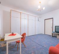 Na predaj rodinný dom Trnava, Zelenečská ulica, pozemok 1085 m2 - Obývacia izba v rodinnom dome s modrým kobercom, rozkladacím gaučom a úložnými skriňami.