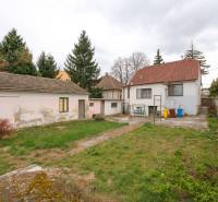 Na predaj rodinný dom Trnava, Zelenečská ulica, pozemok 1085 m2 - Záhrada a budovy rodinného domu na Zelenečskej ulici v Trnave obkolesené stromami.