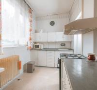 Na predaj rodinný dom Trnava, Zelenečská ulica, pozemok 1085 m2 - Kuchyňa v rodinnom dome s bielymi skrinkami, sporákom a farebnými záclonami.