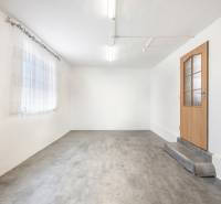 Komerčný objekt s pozemkom – možnosť zmeny na rodinný dom - Biele steny, betónová podlaha, drevené dvere a záclona v obchodných priestoroch.