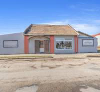 Komerčný objekt s pozemkom – možnosť zmeny na rodinný dom - Obchodné priestory v meste Okoč s výkladnými oknami a šikmou strechou.