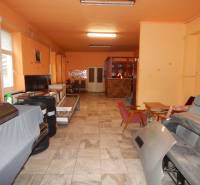  Podnikateľská príležitosť v obci Búč . - Interiér gastro priestorov s oranžovými stenami, skladový priestor so stoličkami a vybavením.