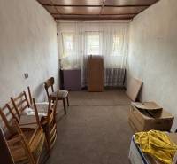 Rodinný dom Martin - Valča - Jednoduchá izba s kartónmi a drevenými stoličkami v rodinnom dome.