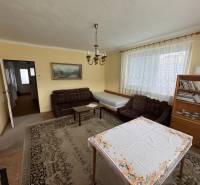 Rodinný dom Martin - Valča - Obývacia izba v rodinnom dome s gaučom, knihovňou a stolom s obrusom.