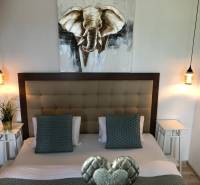 Na predaj štyri apartmány na jednom poschodí Podhájská - Spálňa so štýlovým osvetlením a obrazom slona v 2-izbovom byte.